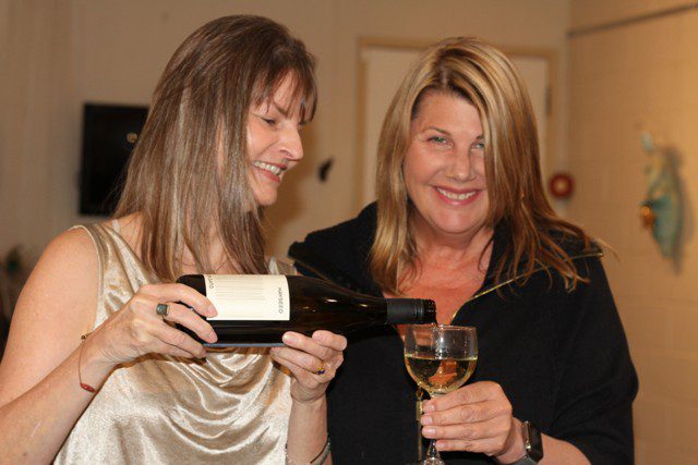 book launch recap - Carolyn Dismuke pouring wine for a friend
